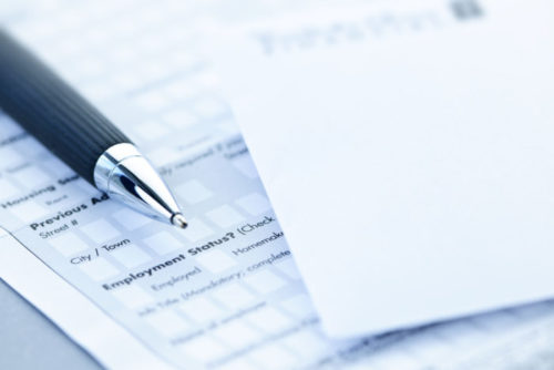 A pen sitting on top of a financial application form.