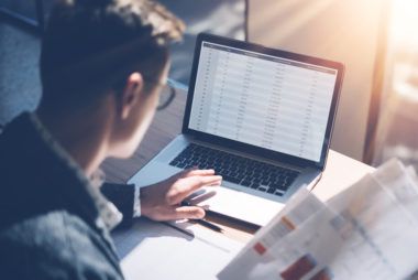 A person checking their online bank account to see if money has been direct deposited.