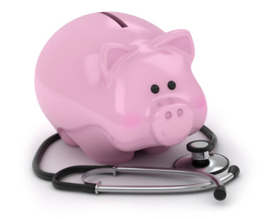 A piggy bank sits on a stethoscope.