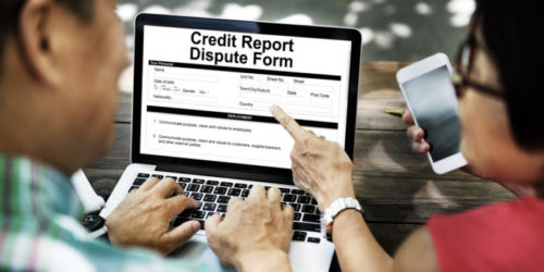 Two people looking at a computer screen that reads "credit report dispute form."