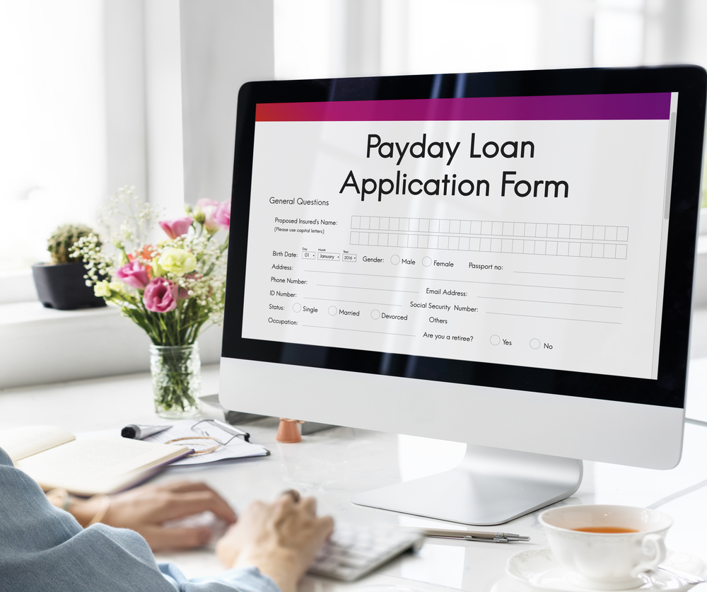 A person filling out a payday loan application form on their computer.