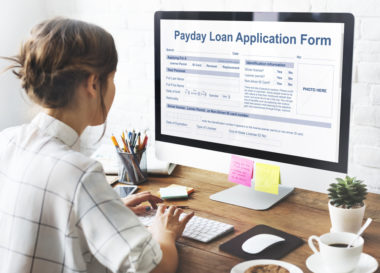 A person filling out a payday loan application form on their computer.