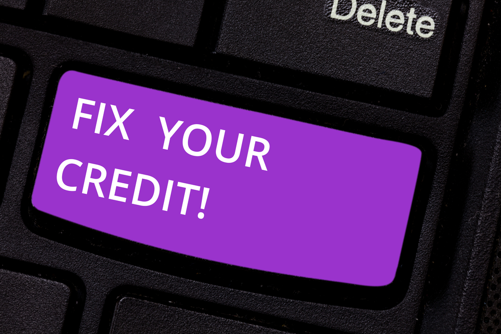 A key on a computer keyboard is highlighted in purple and reads "fix your credit!"