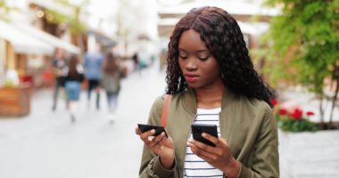 A person holding a credit card while using their phone.