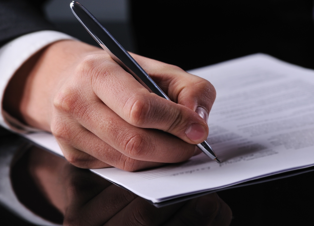 A person signing a loan contract.