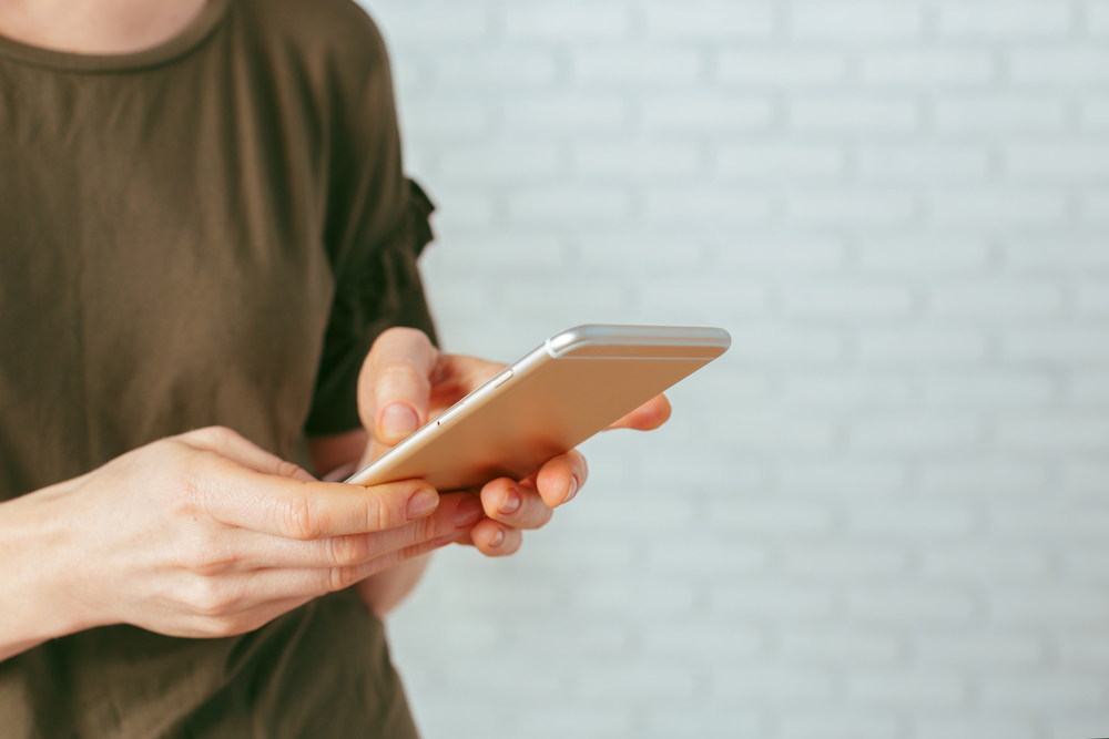 A person standing while using their phone.