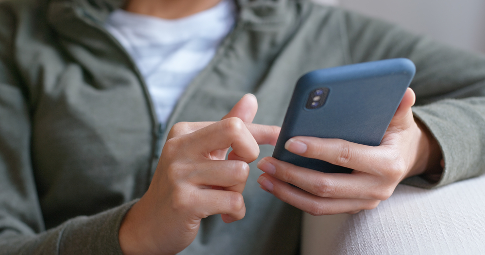 A person sitting down while using their phone.