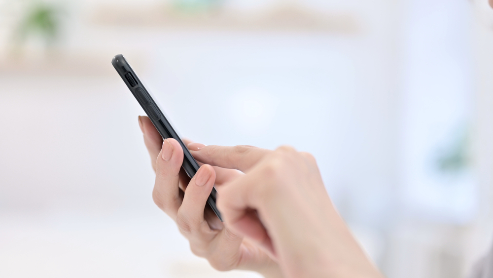 A closeup of a person's hands using a phone.