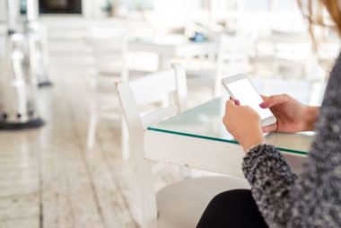 A person sitting in a café, using their phone.