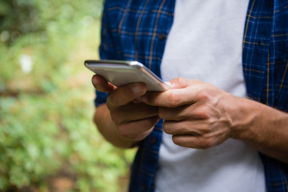 A person in a checkered shirt checking their phone.