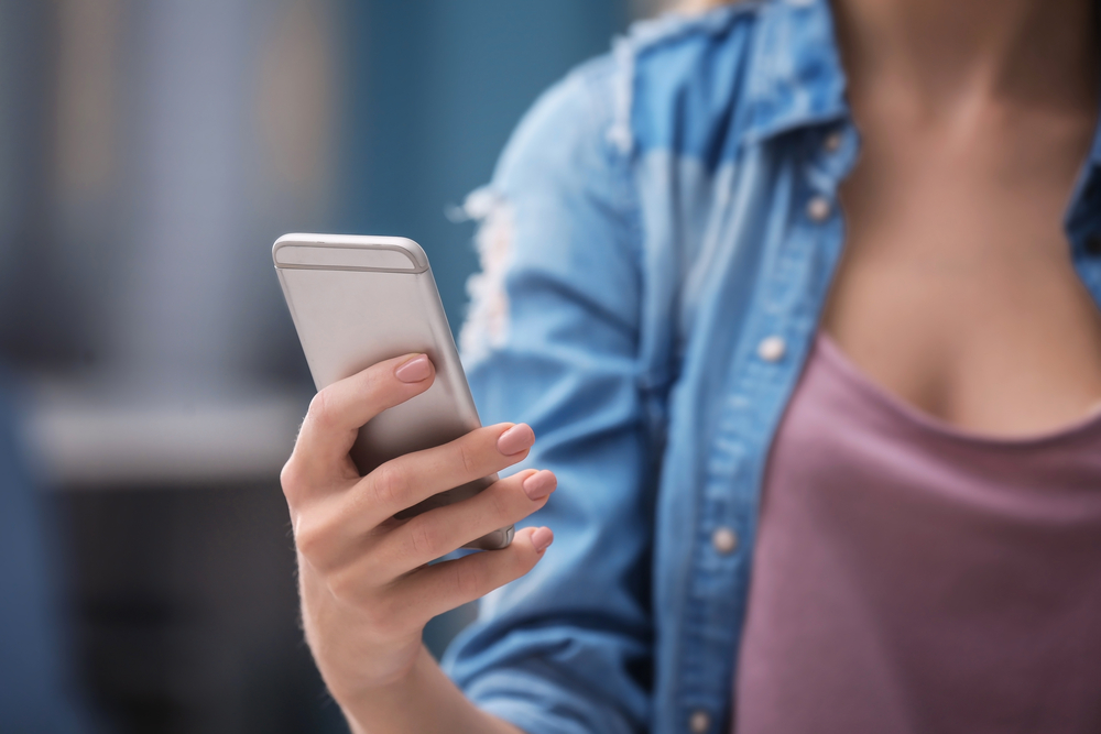 A person using their phone outdoors.