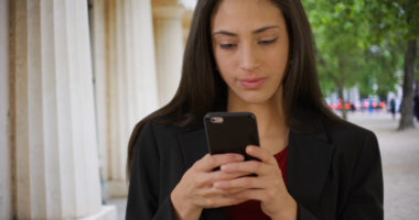 A person checking their phone outdoors.