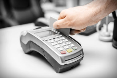 A credit card being swiped through a retail pay terminal.