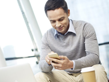 A person sitting down, using their phone.