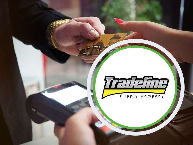 Hand holding a credit card and tradeline logo on it.