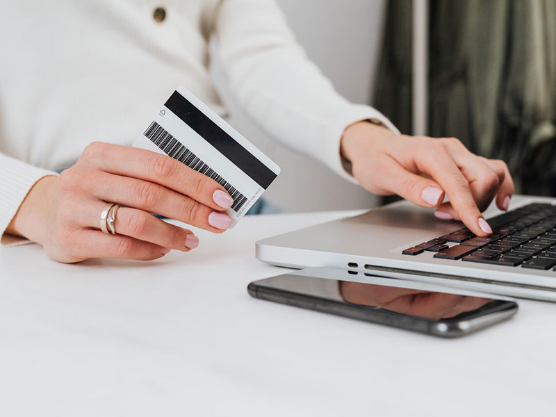 Person using a credit card while using their laptop