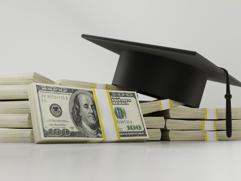 money and graduation cap on a table