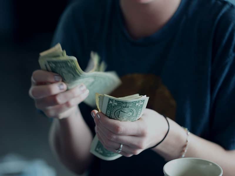 A woman counting dollar bills